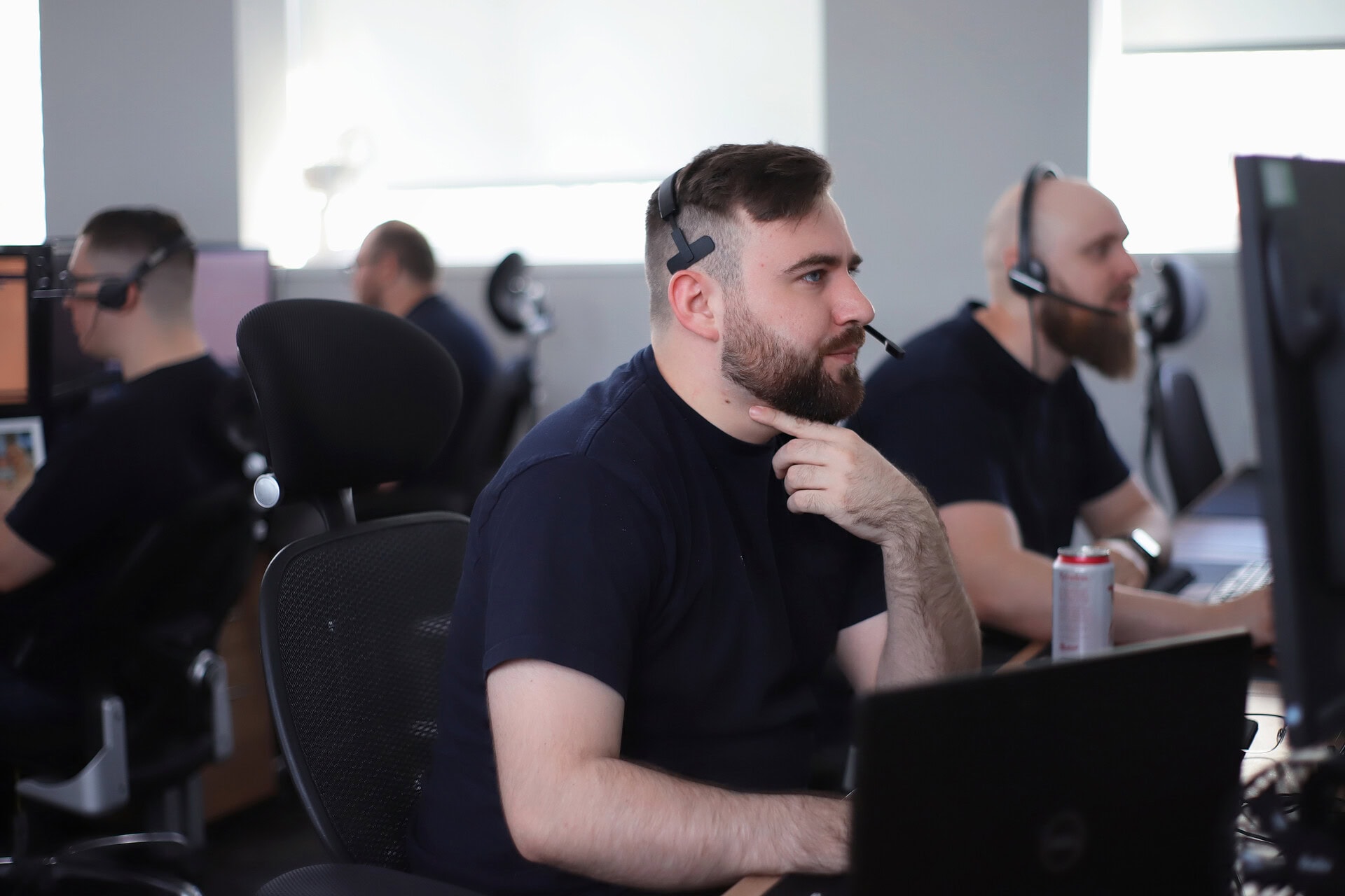 Office Shot of the commited Team Working at Their Computers Wearing Headsets