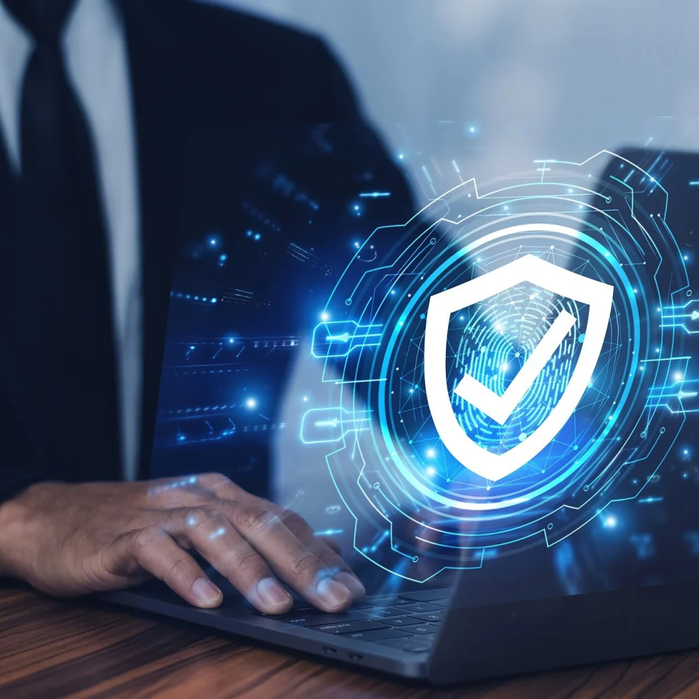 Person Typing on a Laptop With a Security Icon Above it