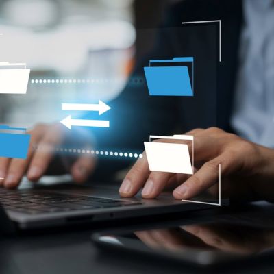 Person Using a Computer With Document Icons Above it