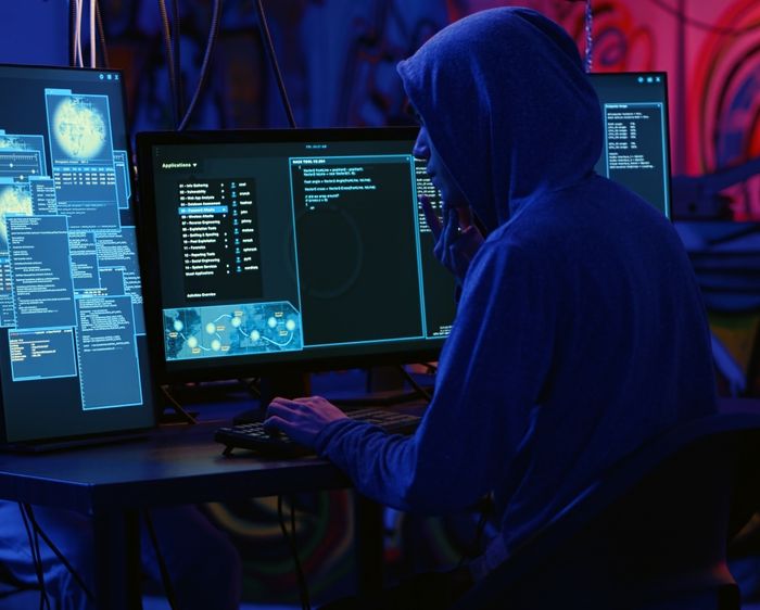 Hooded Person Typing on a Computer