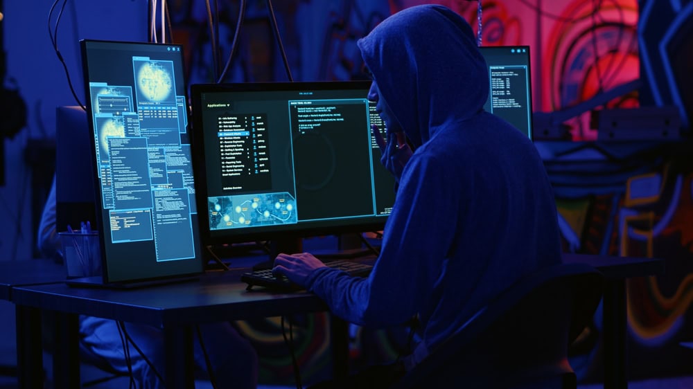 Hooded Person Typing on a Computer