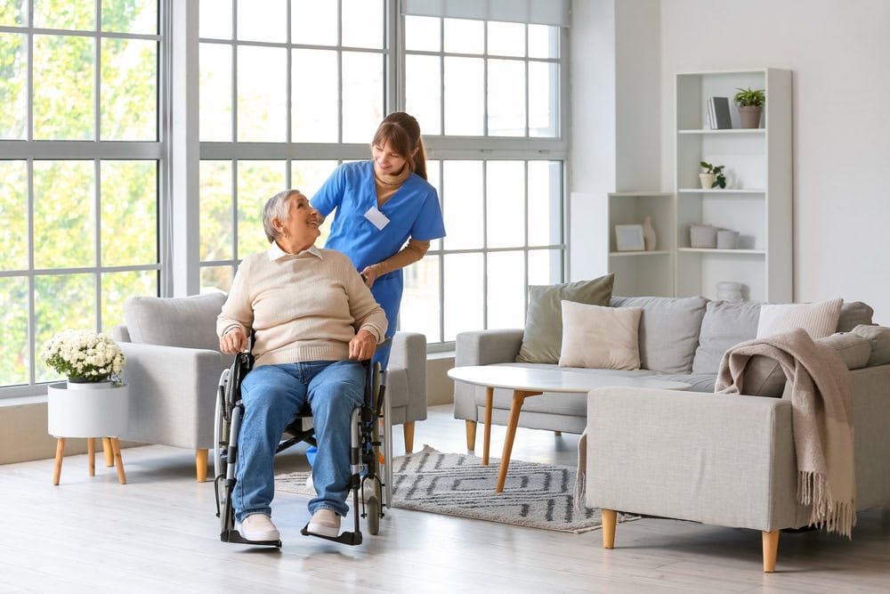 Carer Pushing an Elderly Person in a Wheelchair Whilst They Smile at Each Other