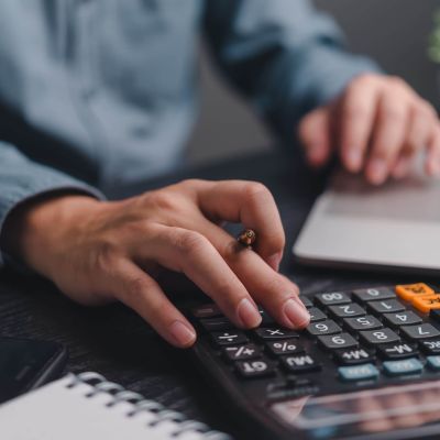 Businessman,Using,Calculator,Bookkeeping,Payroll,And,Budget,Tax.,Business,Document